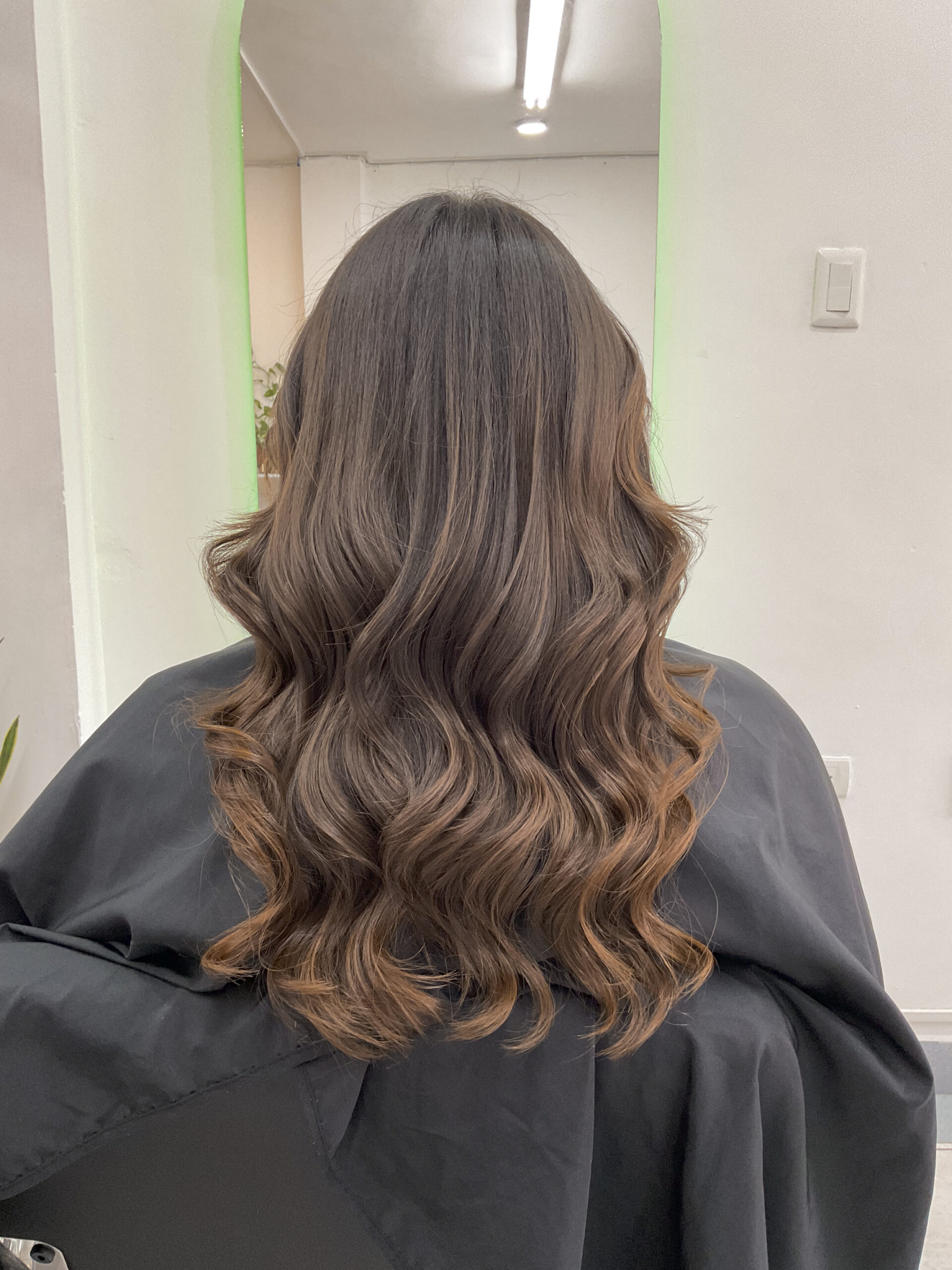 Melena castaña con ondas y reflejos cálidos